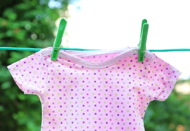 Photo of Baby clothes on laundry line outdoors on sunny day