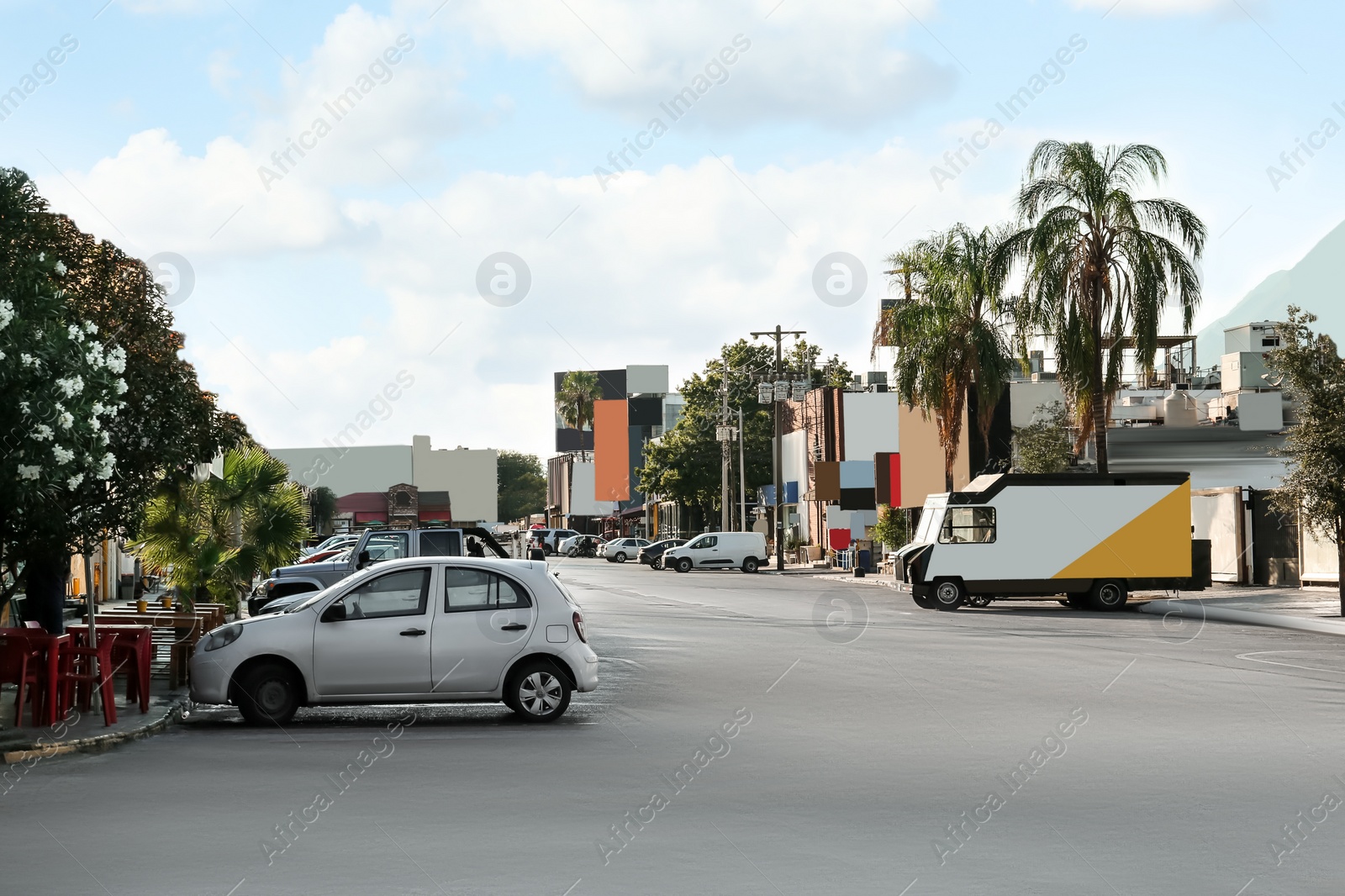 Photo of Picturesque view of city street with cars on road near beautiful buildings