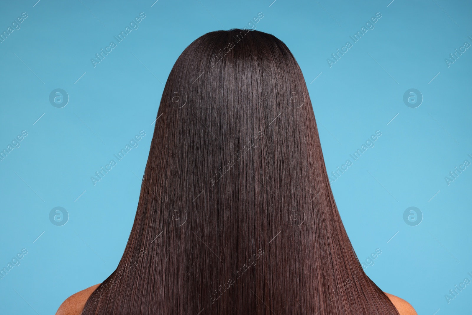 Photo of Woman with healthy hair after treatment on light blue background, back view