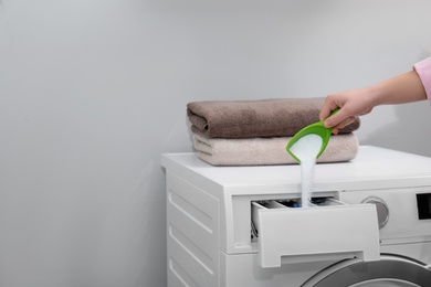 Photo of Woman pouring powder into drawer of washing machine indoors, closeup with space for text. Laundry day