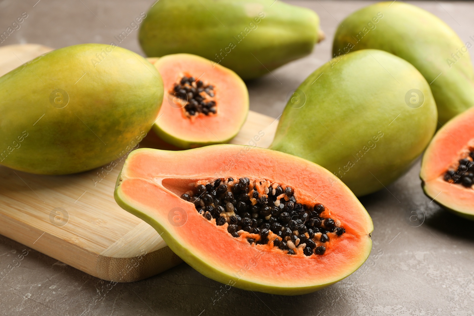 Photo of Fresh ripe papaya fruits on grey table