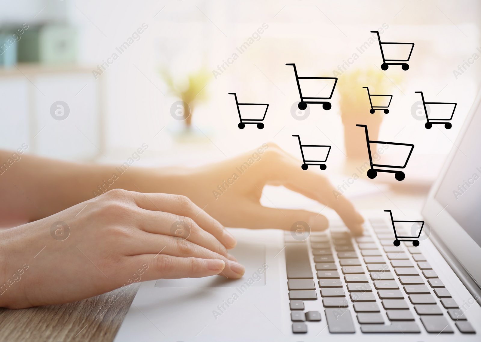 Image of Woman using laptop for online shopping at wooden table, closeup