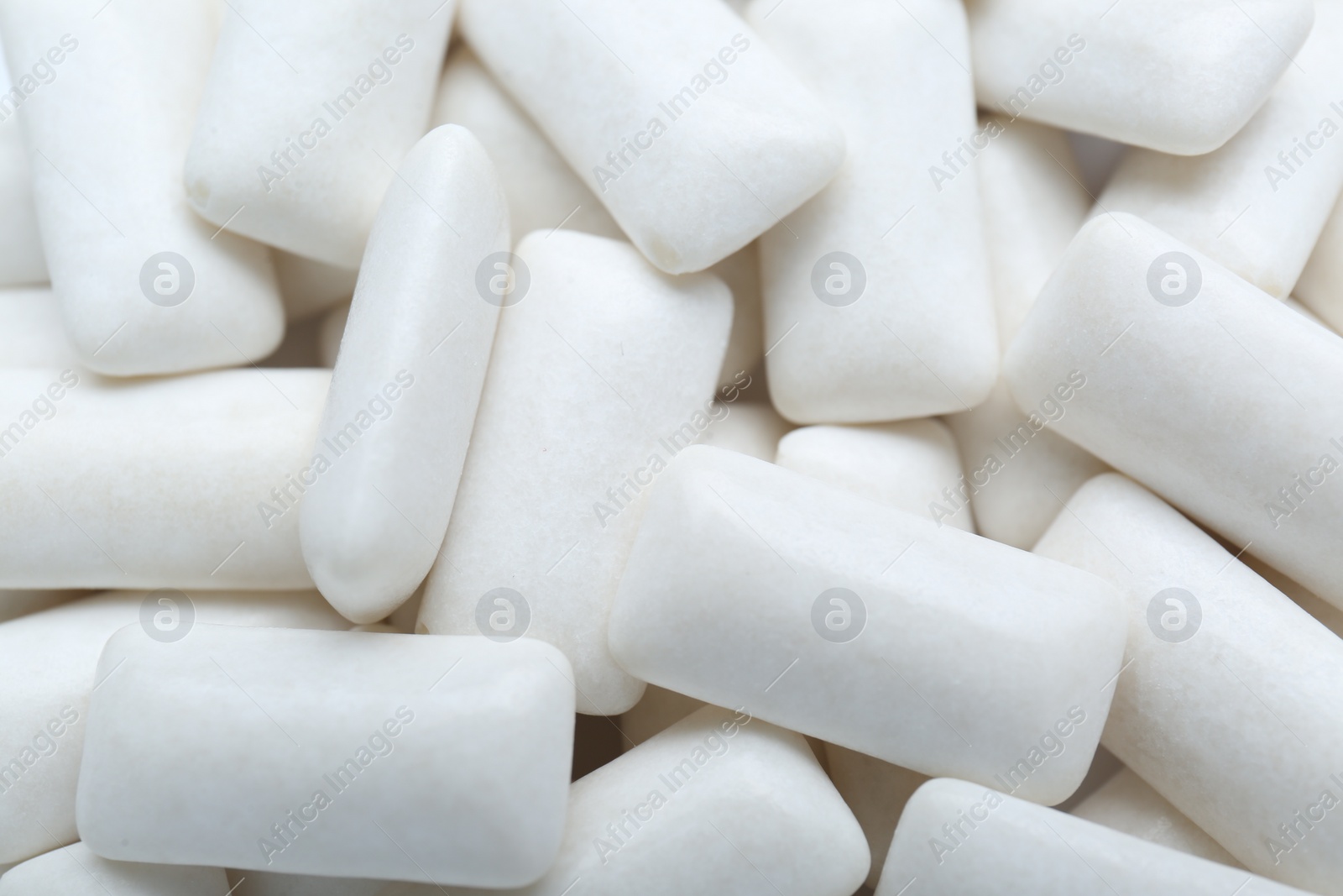 Photo of Tasty white chewing gums as background, top view