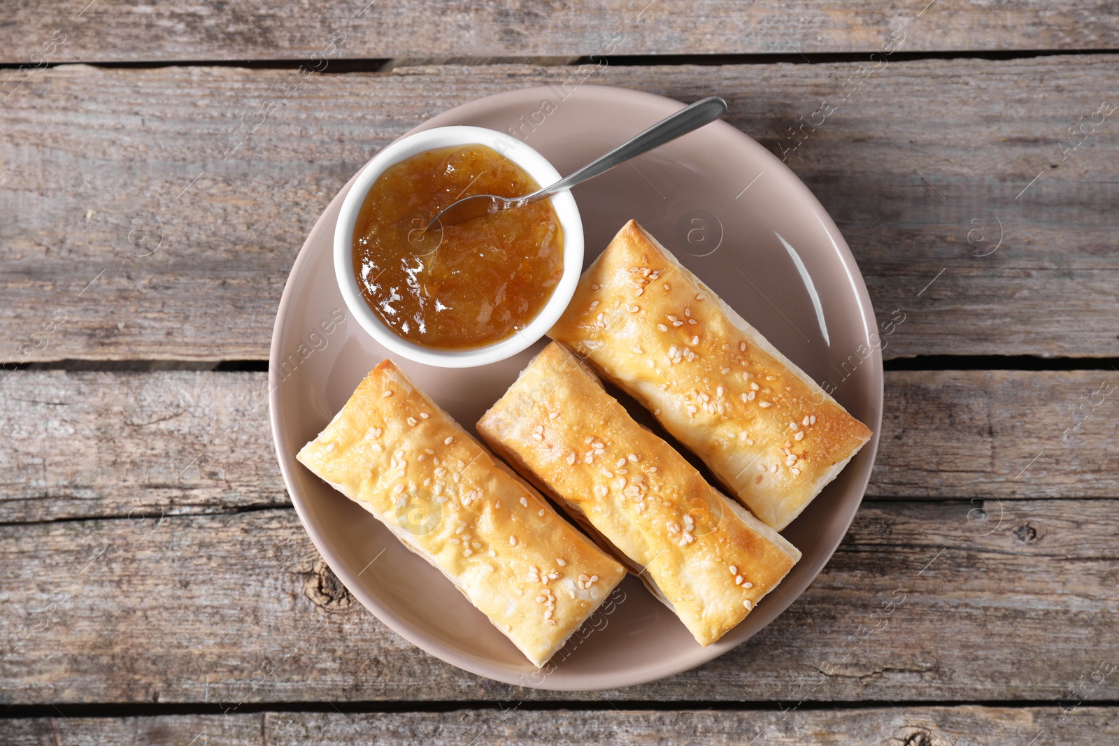 Photo of Delicious puff pastry served on wooden table, top view