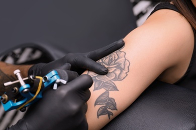 Professional artist making tattoo in salon, closeup