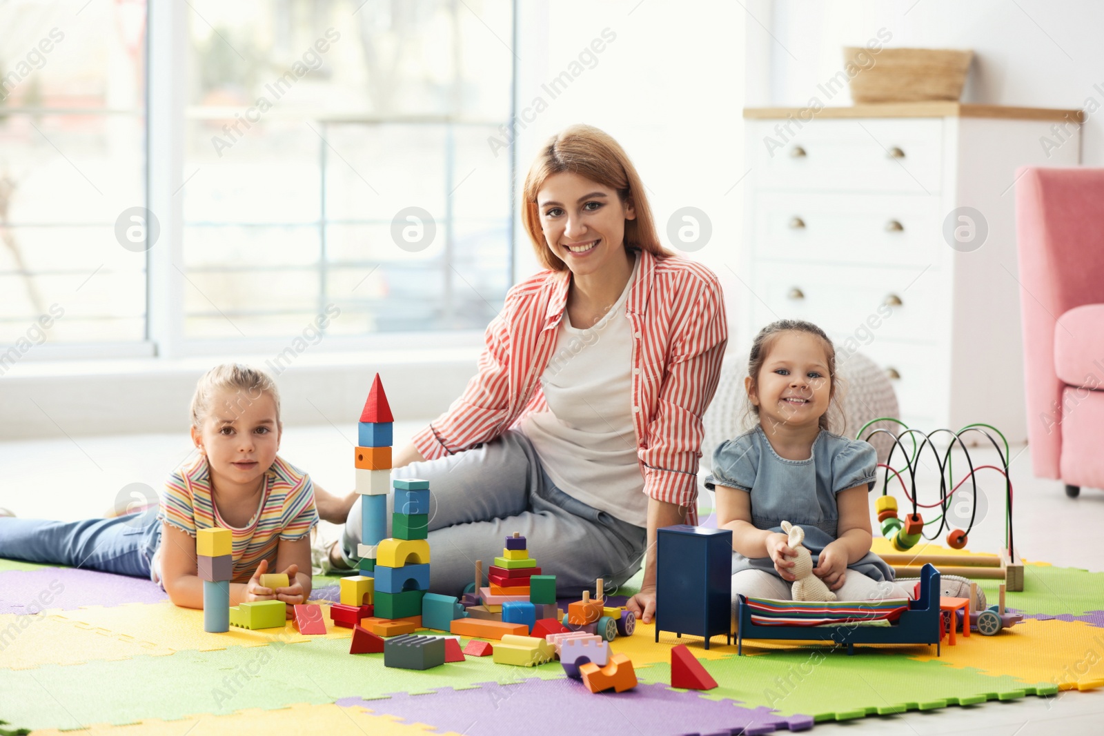 Photo of Mother playing with her children at home