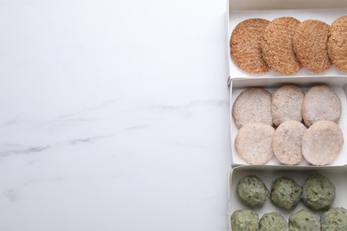 Different raw vegan meat products on white marble table, flat lay. Space for text