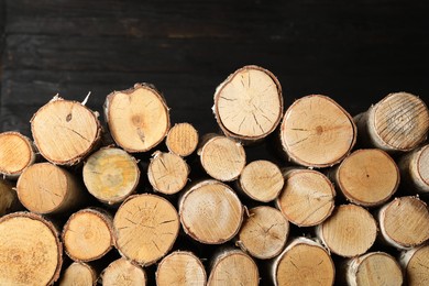 Photo of Cut firewood on black background. Heating in winter