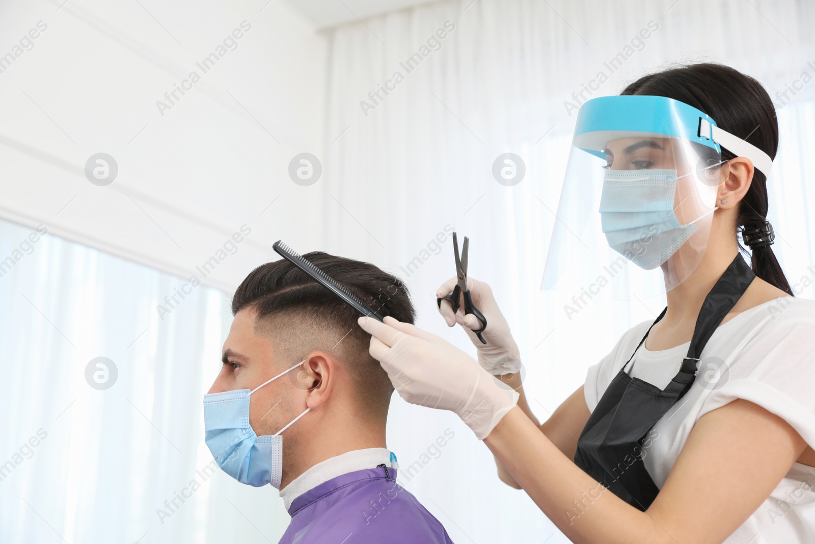 Photo of Professional stylist working with client in salon. Hairdressing services during Coronavirus quarantine