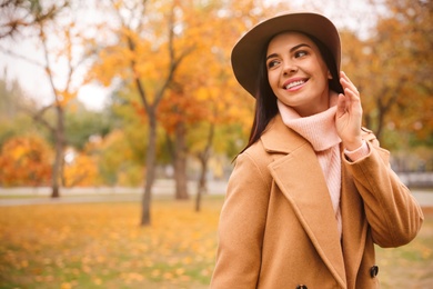 Photo of Young woman wearing stylish clothes in autumn park, space for text
