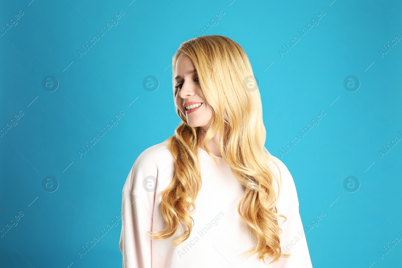 Photo of Portrait of beautiful young woman with dyed long hair on blue background