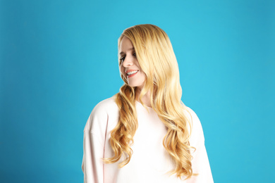 Photo of Portrait of beautiful young woman with dyed long hair on blue background