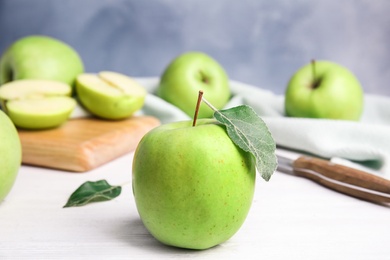 Photo of Fresh ripe green apples on white wooden table against blue background, space for text