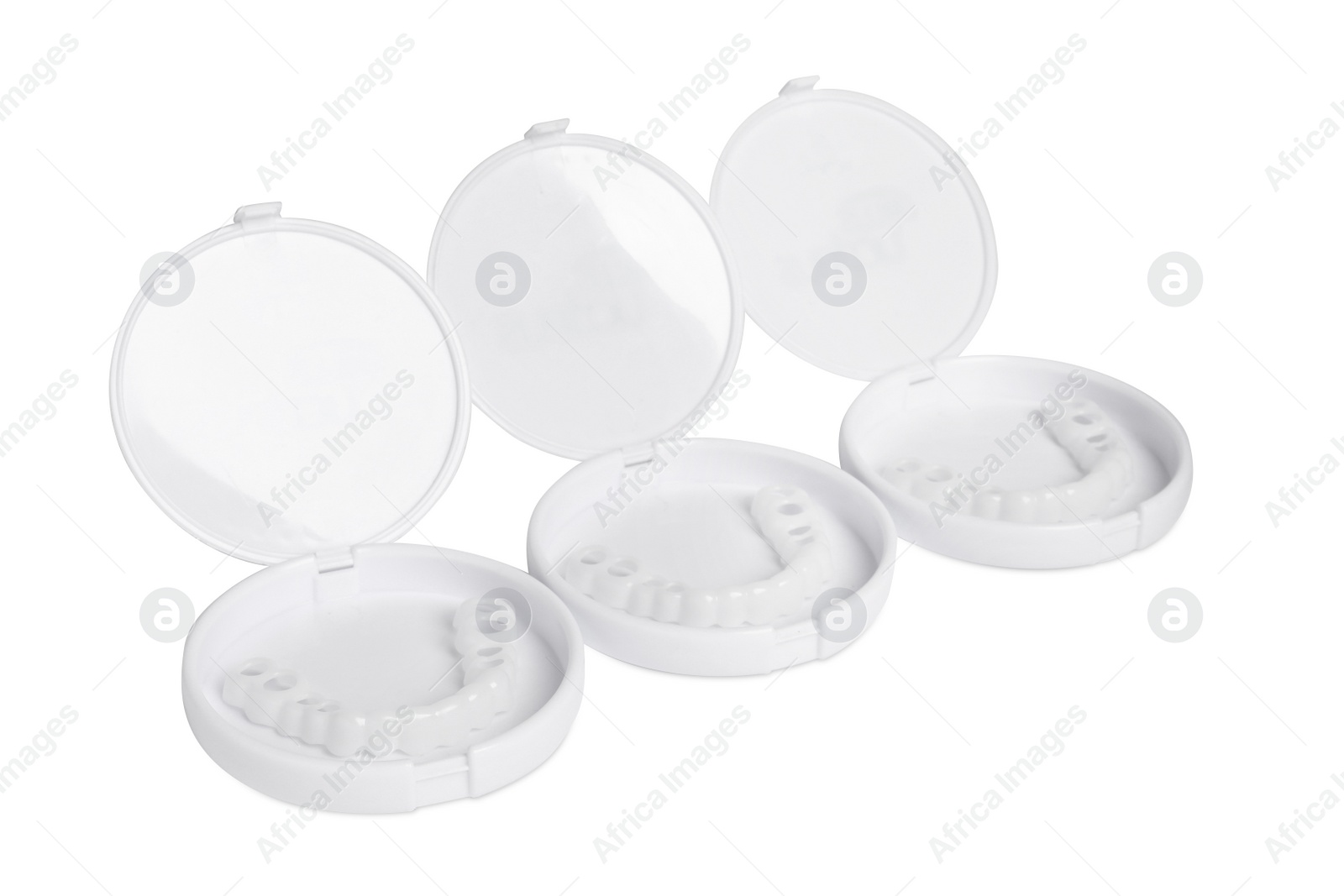 Photo of Containers with dental mouth guards on white background. Bite correction