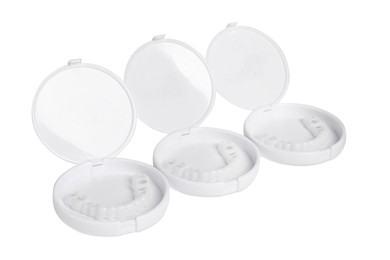 Photo of Containers with dental mouth guards on white background. Bite correction