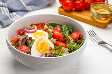 Photo of Delicious salad with boiled egg, bacon and vegetables on white wooden table, closeup