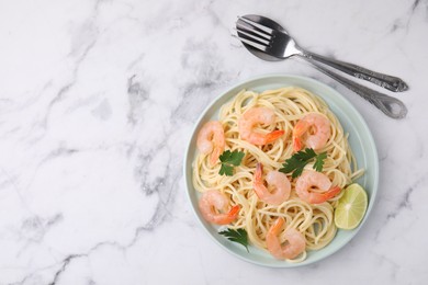 Photo of Tasty spaghetti with shrimps, lime and parsley served on white marble table, top view. Space for text