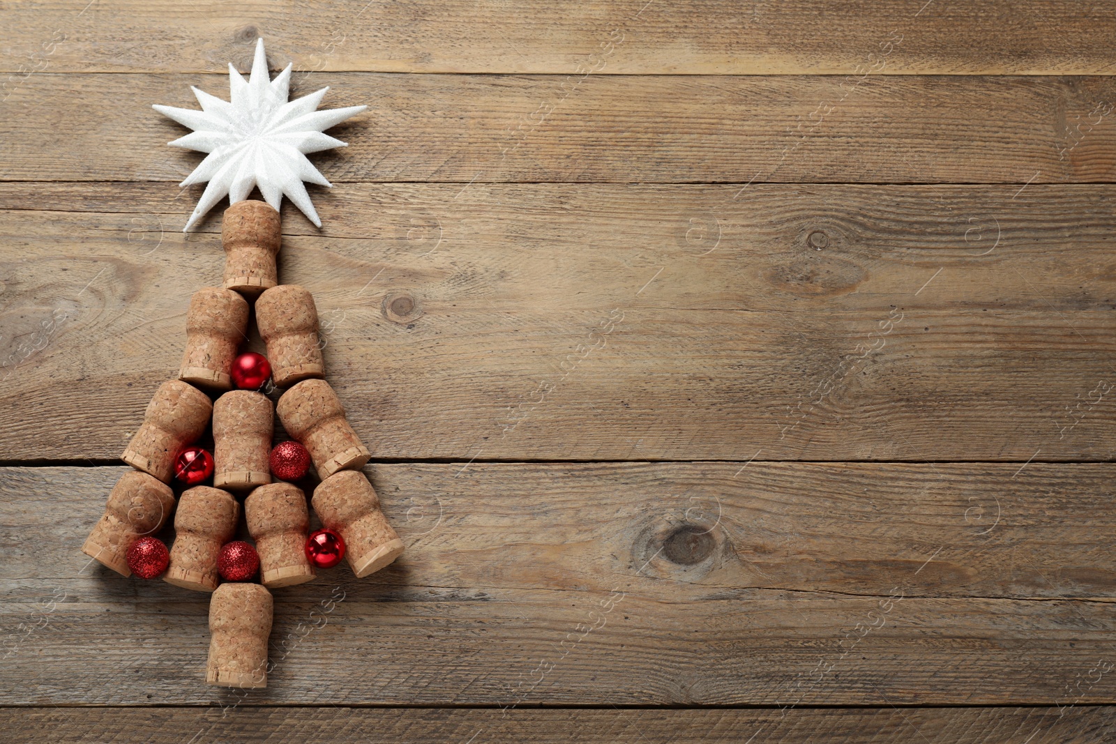 Photo of Christmas tree made of wine corks and holiday decoration on wooden table, flat lay. Space for text