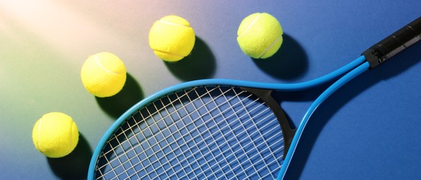 Image of Tennis racket and balls on blue background, flat lay. Banner design