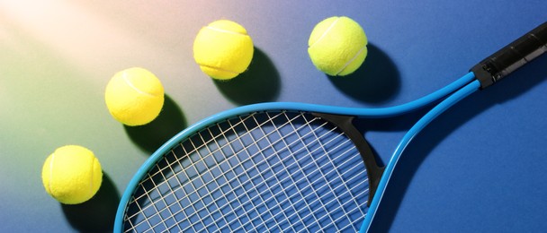 Tennis racket and balls on blue background, flat lay. Banner design