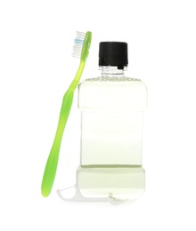 Bottle with mouthwash and toothbrush on white background