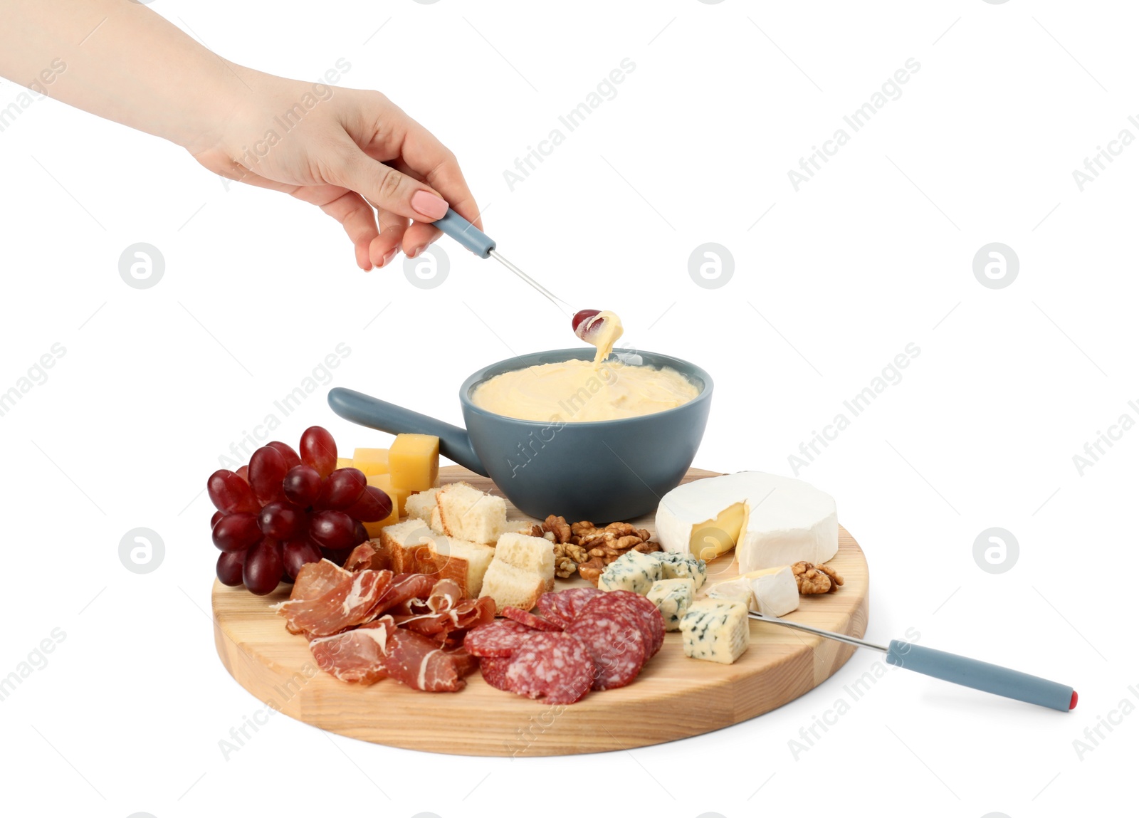 Photo of Woman dipping grape into fondue pot with melted cheese on white background, closeup