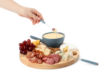 Woman dipping grape into fondue pot with melted cheese on white background, closeup