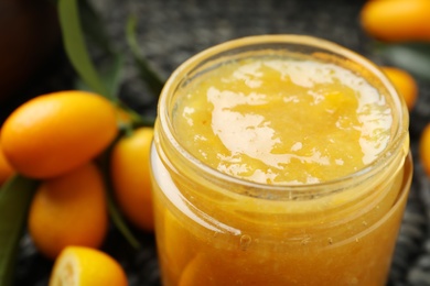 Photo of Delicious kumquat jam in jar, closeup view