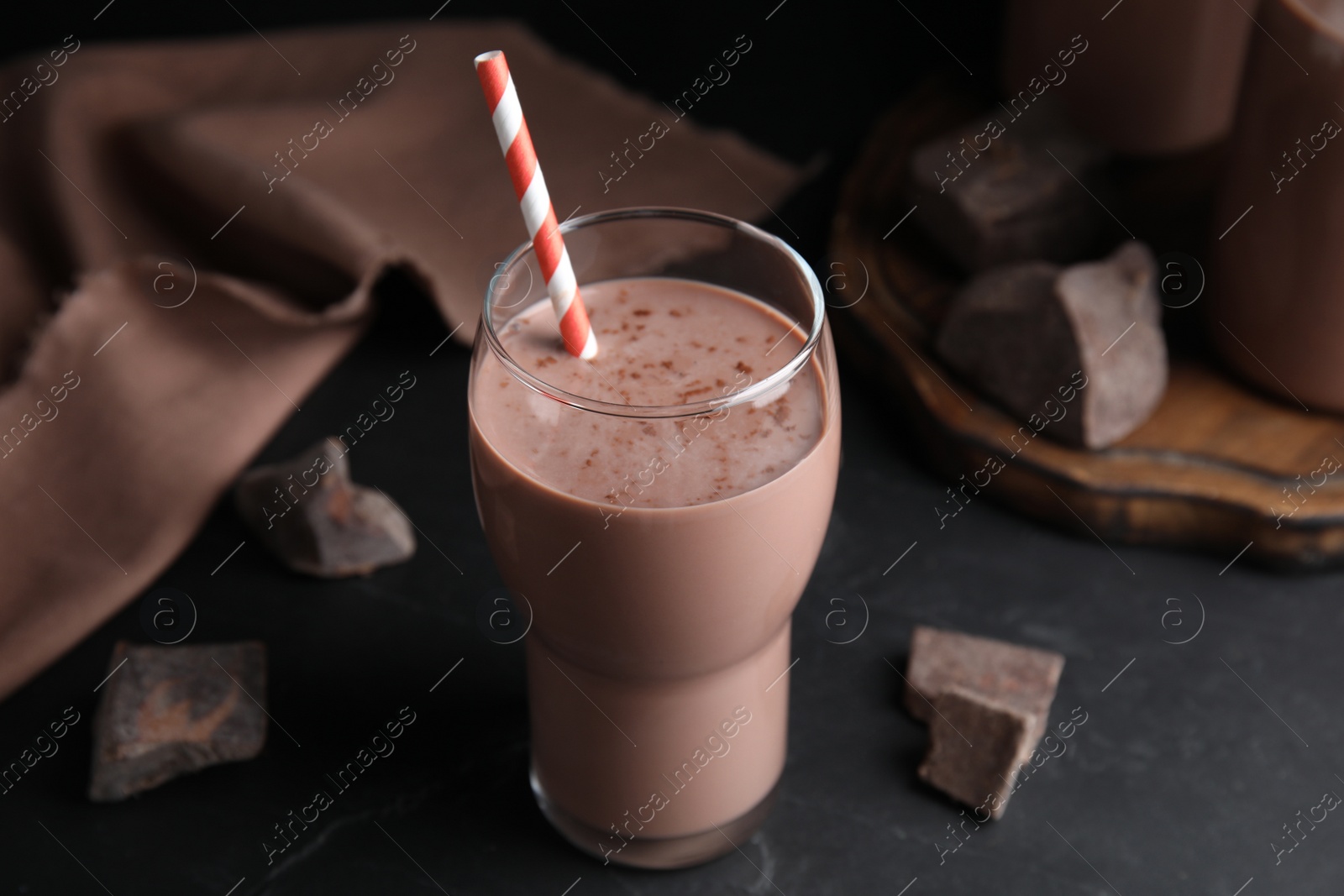 Photo of Delicious chocolate milk in glass on black table