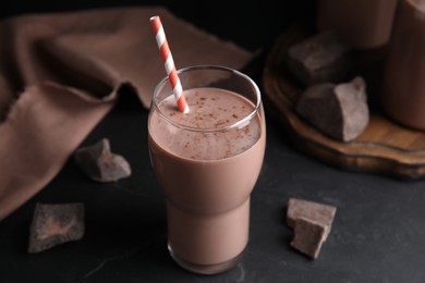 Delicious chocolate milk in glass on black table