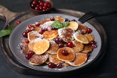 Photo of Cereal pancakes with cranberries served on black table