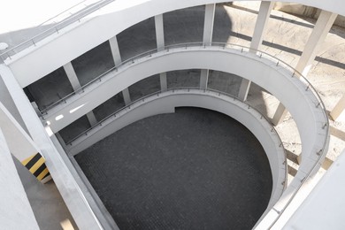 Photo of Open car parking garage with ramp on sunny day, above view