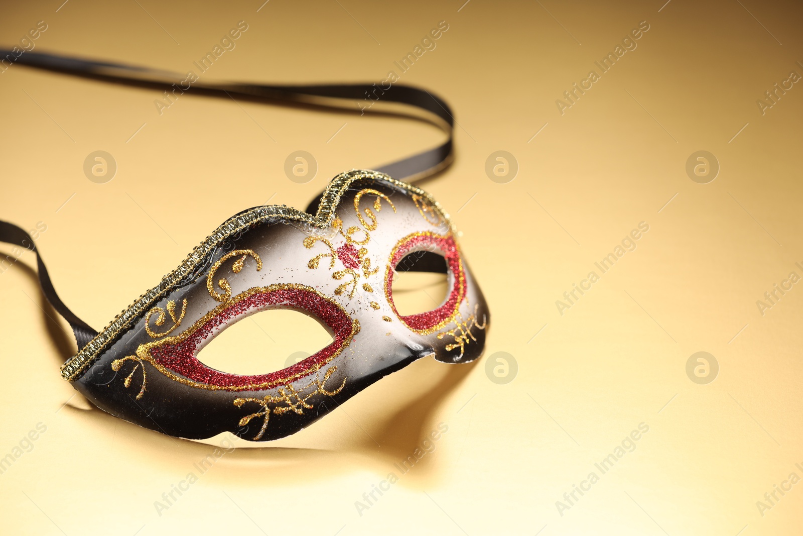 Photo of Elegant face mask on beige background, space for text. Theatrical performance