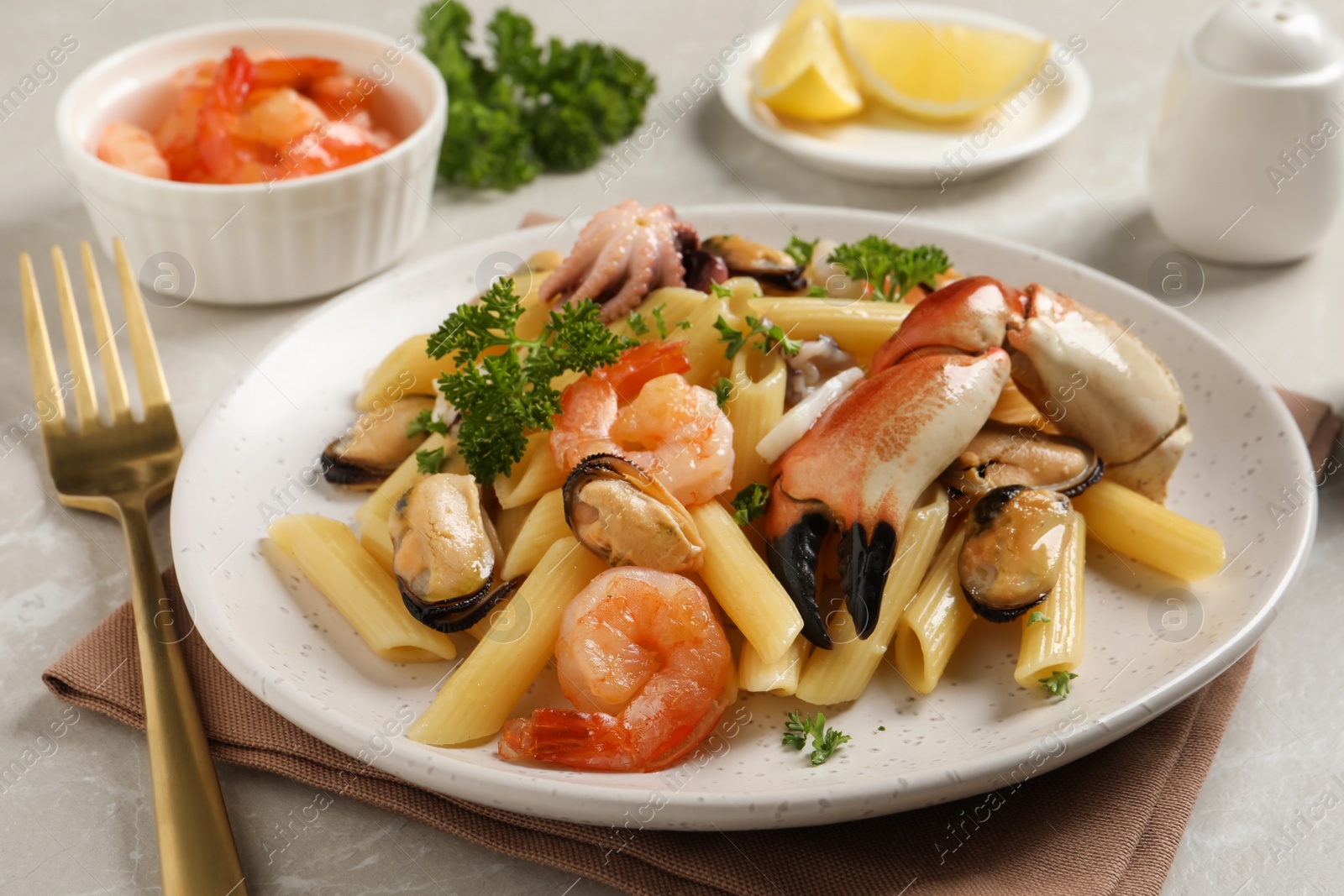 Photo of Delicious pasta with sea food served on light grey table