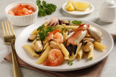 Delicious pasta with sea food served on light grey table