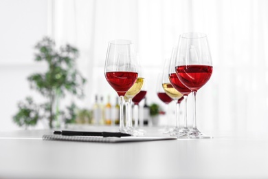 Photo of Glasses with delicious wine on table indoors