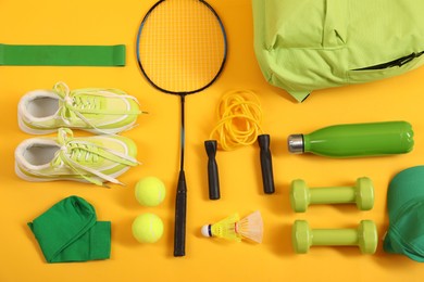 Different sports equipment on yellow background, flat lay