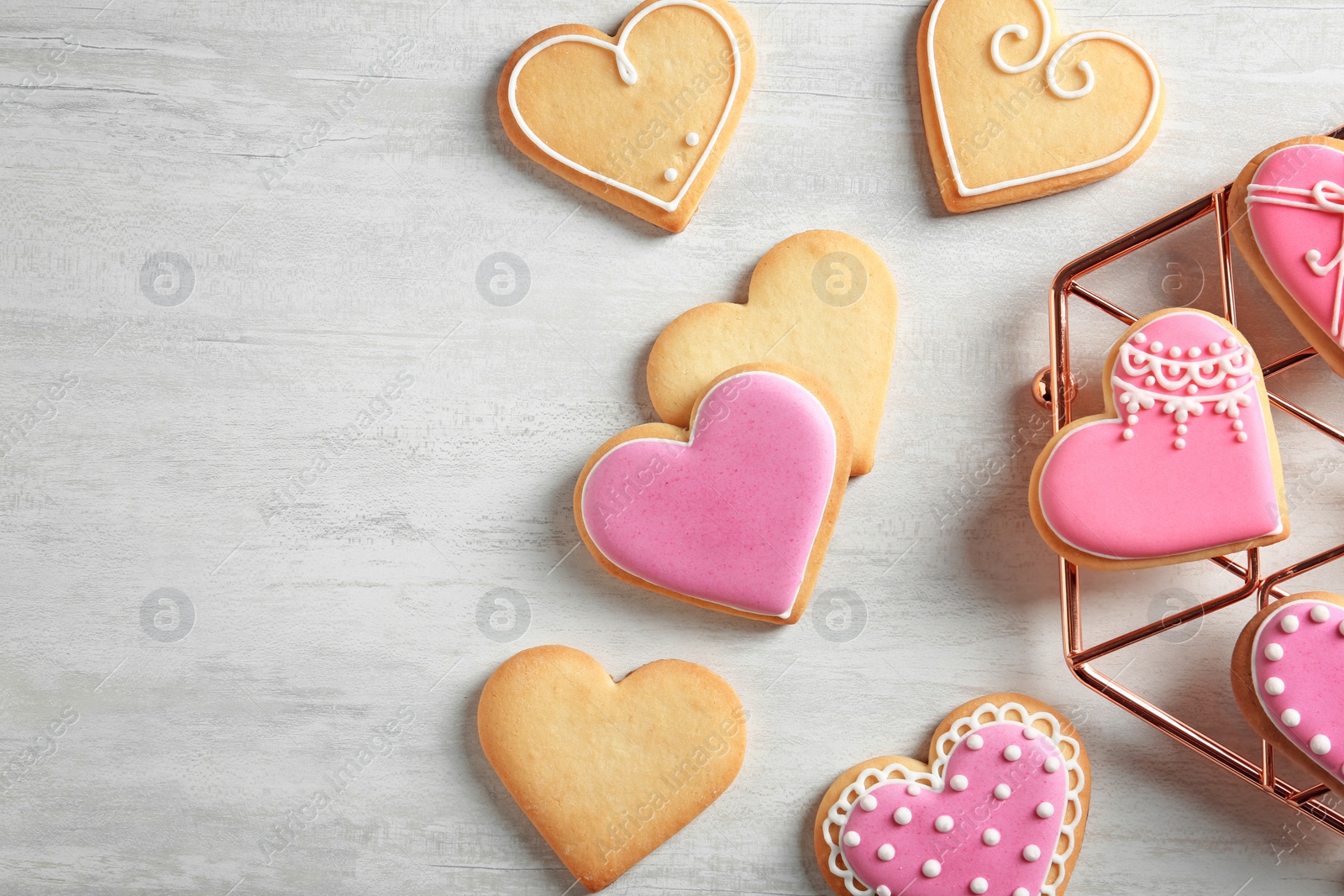 Photo of Flat lay composition with decorated heart shaped cookies and space for text on table