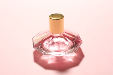 Photo of Elegant bottle of perfume on pink background