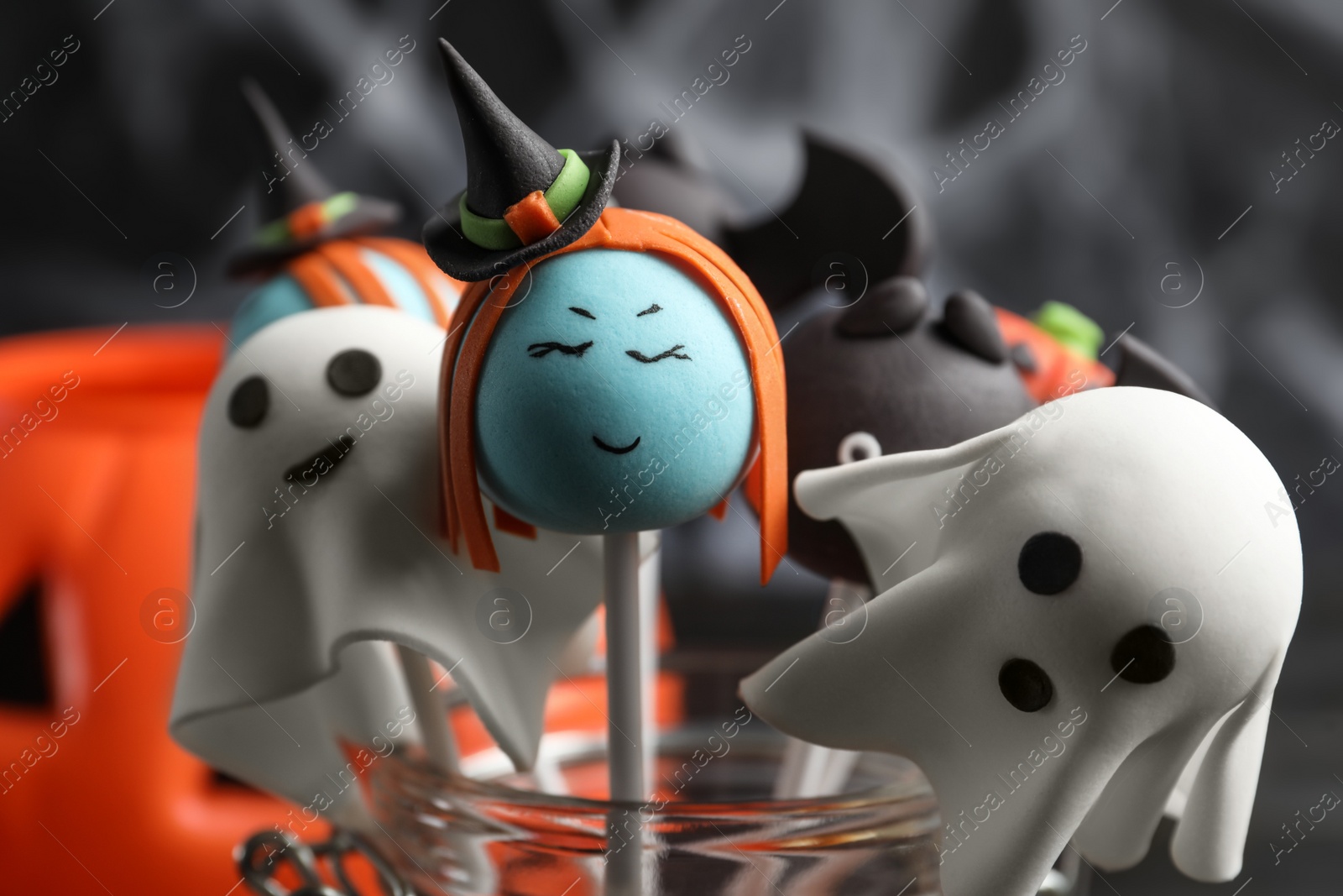 Photo of Different Halloween themed cake pops on dark background, closeup