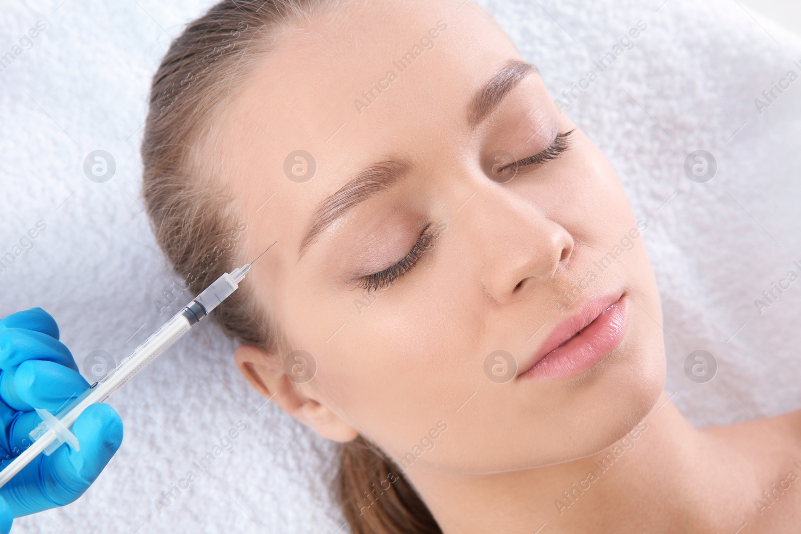 Photo of Young woman getting facial injection in clinic. Cosmetic surgery concept