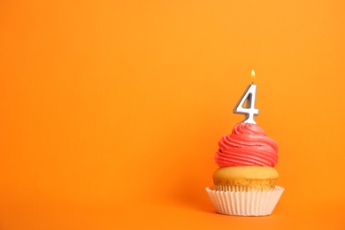 Photo of Birthday cupcake with number four candle on orange background, space for text