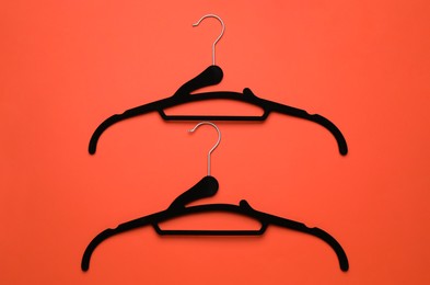 Photo of Empty clothes hangers on red background, flat lay