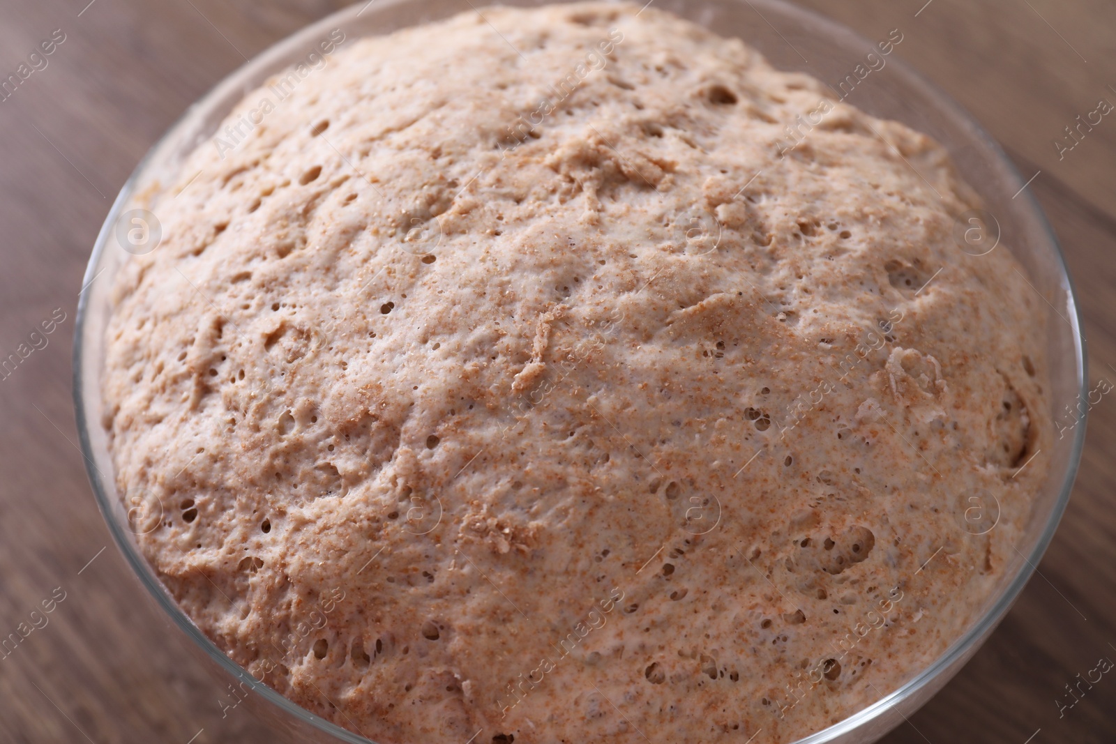 Photo of Fresh sourdough in bowl on wooden table, closeup