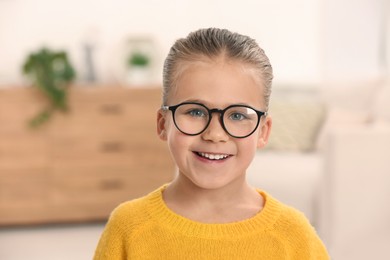 Portrait of cute little girl wearing glasses indoors