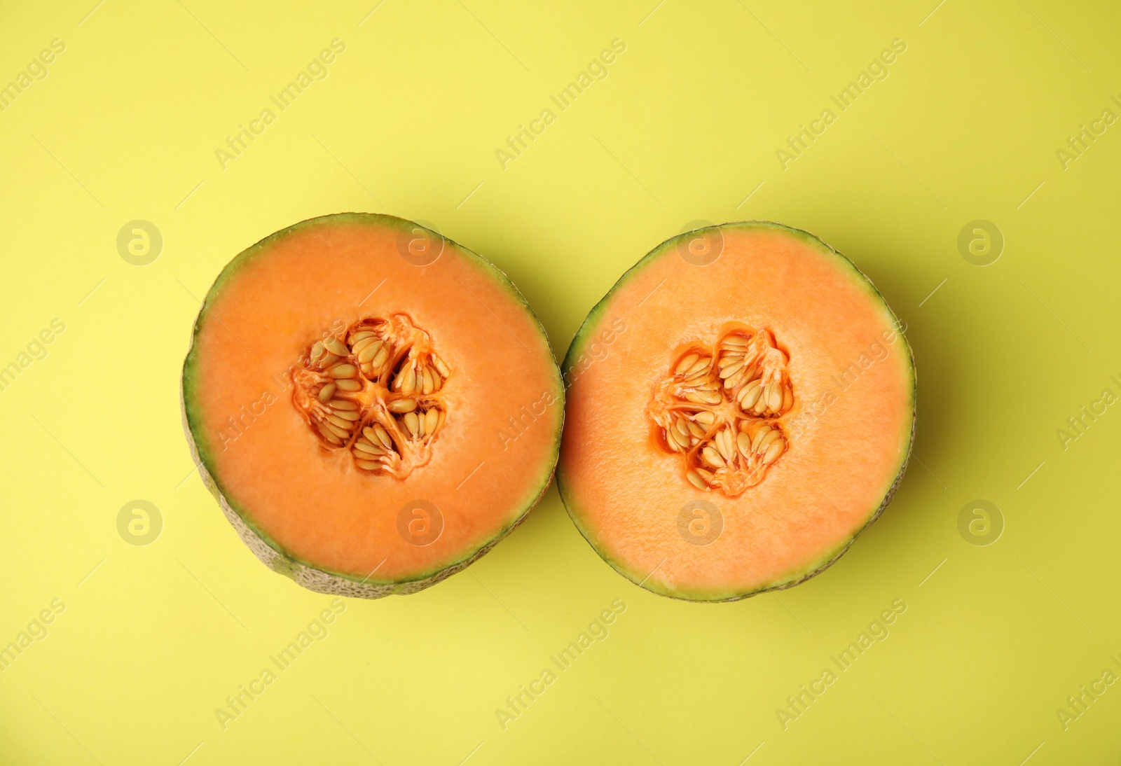 Photo of Tasty colorful ripe melons on yellow background, flat lay