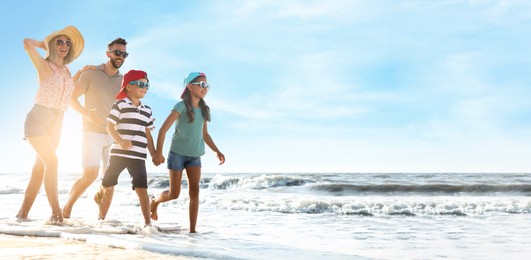 Image of Happy family running on sandy beach near sea, space for text. Banner design