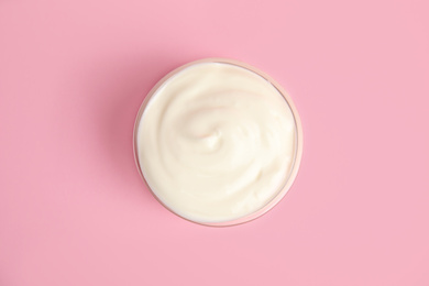 Photo of Tasty organic yogurt on pink background, top view