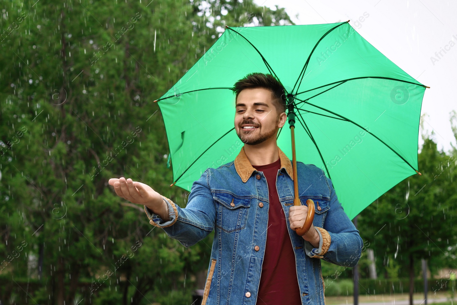 Photo of Man with umbrella outdoors on rainy day