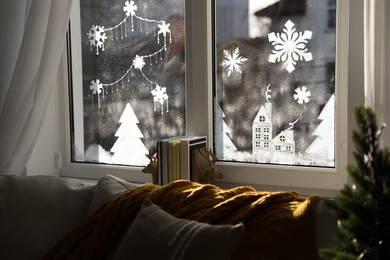 Photo of Beautiful drawing made of artificial snow on window at home. Christmas decor